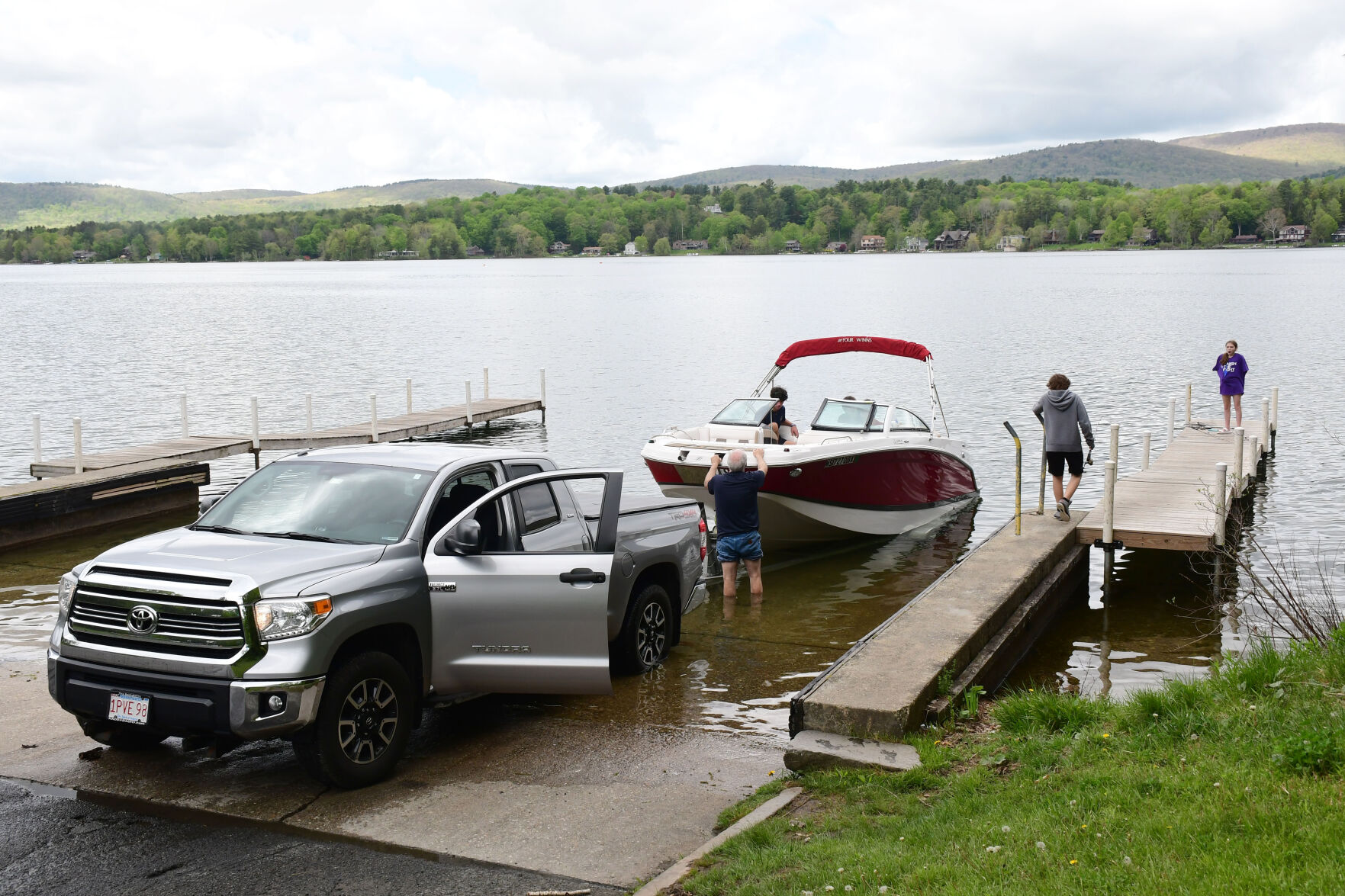 A boat goes in the water at Onota Lake